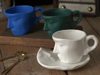 Ajoutez une touche artistique à vos pauses café avec cette tasse et soucoupe en céramique au design de visage abstrait. 260 ml, 5 couleurs, avec cuillère assortie. Idéale pour offrir.