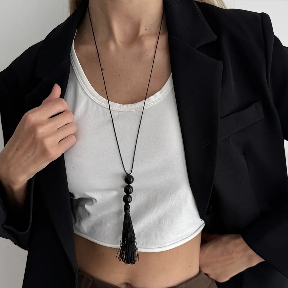 Collier Long Pendentif Pompon Perlé Noir – Bijou Créatif Tendance Femme 1 Collier long pendentif pompon perlé noir pour femme. Bijou créatif en acrylique avec fil de cire réglable, idéal pour pull, tenue chic ou cadeau tendance.
